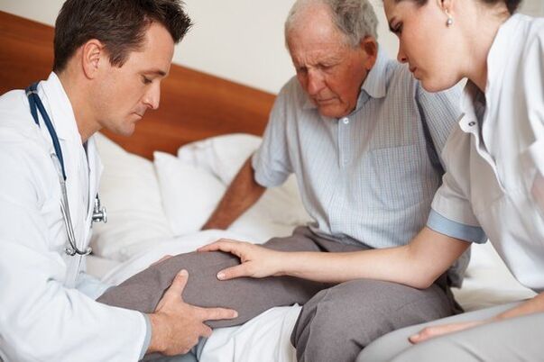 Le médecin examine le genou du patient